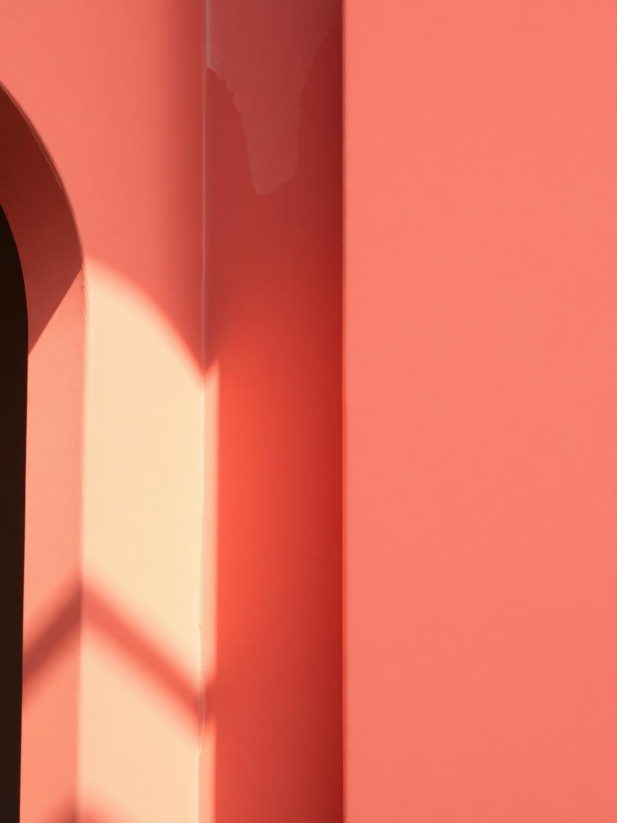 Warm light and soft shadow falling across a clay-colored wall